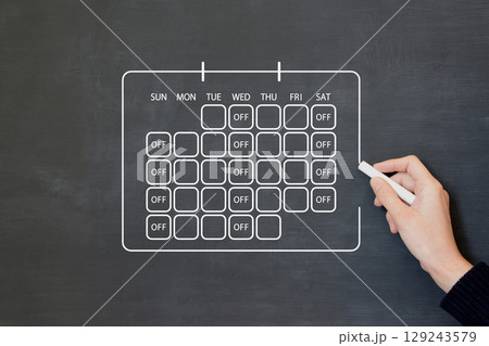 週休三日制度が反映されたカレンダーを黒板に描く人物 129243579