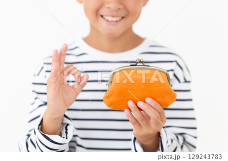 オレンジのがま口財布を持って丸サインをする小学生の男の子 オレンジのがま口財布を持って丸サインをする小学生の男の子 129243783