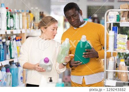 Couple man and woman choosing detergent in store Couple man and woman choosing detergent in store 129243882