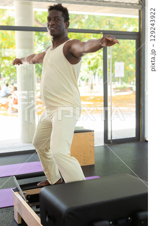 African american man is engaged in pilates training in gym African american man is engaged in pilates training in gym 129243922