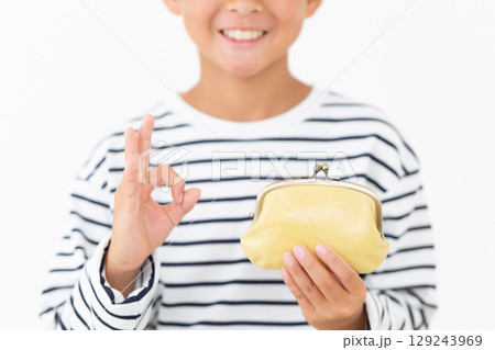 黄色のがま口財布を持って丸サインをする小学生の男の子 129243969