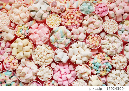 Confectionery and sweeties varieties background: light pink and white marshmallows, sugar confetti and candies, selective focus Confectionery and sweeties varieties background: light pink and white marshmallows, sugar confetti and candies, selective focus 129243994