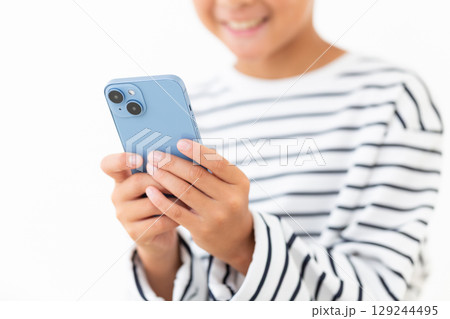 スマホを持つ小学生の男の子 129244495