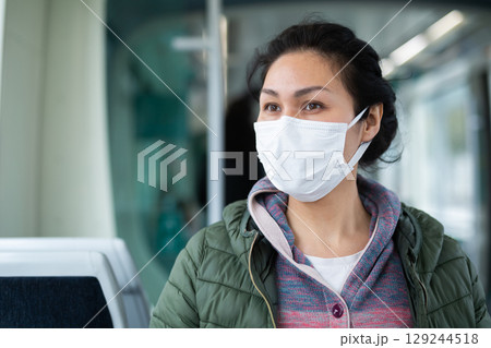Woman in protective mask sitting in subway train 129244518