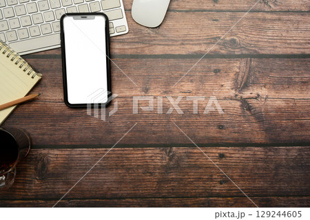 Flat lay of smartphone with blank screen on rustic wooden desk Flat lay of smartphone with blank screen on rustic wooden desk 129244605