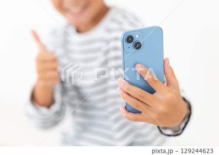スマホで自撮りをする小学生の男の子 129244623