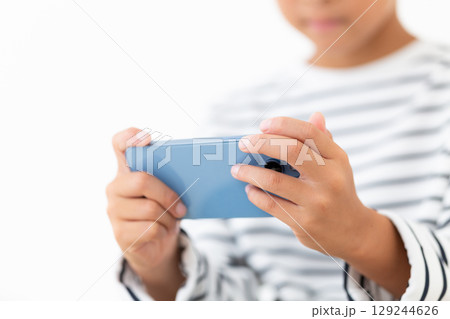 スマホを持つ小学生の男の子 129244626