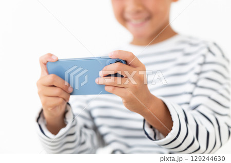 スマホを持つ小学生の男の子 129244630