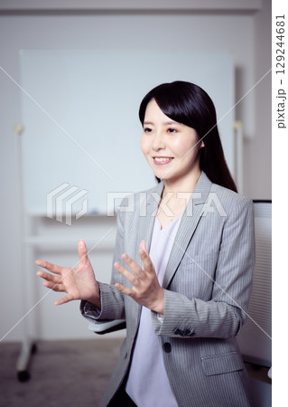 ホワイトボードの前でインタビューに応える女性 129244681