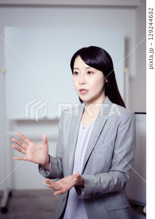 ホワイトボードの前でインタビューに応える女性2 129244682
