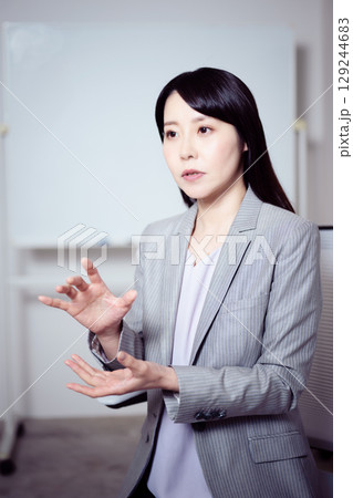 ホワイトボードの前でインタビューに応える女性3 129244683