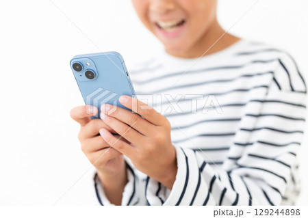 スマホを持つ小学生の男の子 129244898