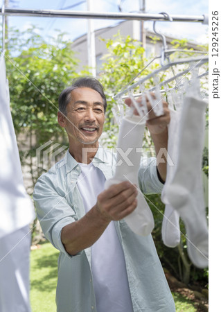 洗濯物を干す60代の男性 129245226