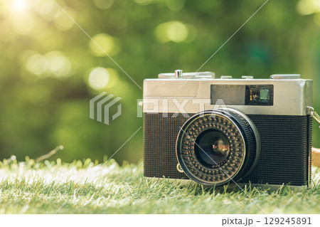 closeup vintage classic compact film camera at green outdoor with copy space for text 129245891