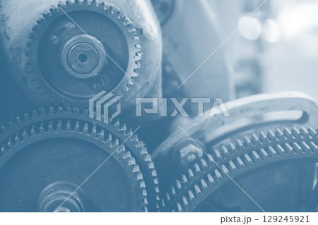 Gear industry background, Mechanical cog wheel in machine, Heavy industry machinery blue color tone 129245921