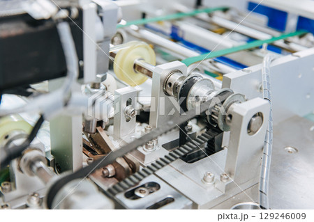 Face mask, Surgical mask production line, Closeup machine conveyor belt roller in hygiene factory 129246009