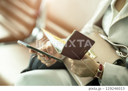 business women using smartphone application self check in with ticket boarding pass and passport business women using smartphone application self check in with ticket boarding pass and passport 129246013