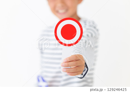 丸のプレートを持って笑う小学生の男の子 丸のプレートを持って笑う小学生の男の子 129246425