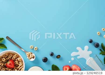 Healthy breakfast with cereal, milk, strawberries, blueberries, and mint on a blue background. Space for your text or design. Healthy breakfast with cereal, milk, strawberries, blueberries, and mint on a blue background. Space for your text or design. 129246519