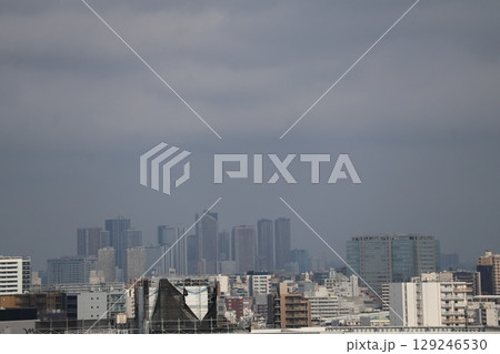 雲の多い空と高層ビルのビル群のある都会の街並みの風景 129246530