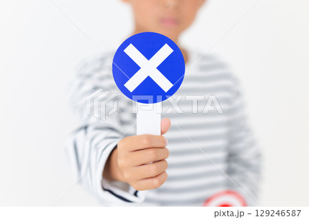 バツのプレートを持つ小学生の男の子 バツのプレートを持つ小学生の男の子 129246587