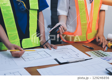Closeup of team of industrial engineers meeting analyze machinery blueprints consult project on table in manufacturing factory. Working in manufacturing plant or production plant. 129246856