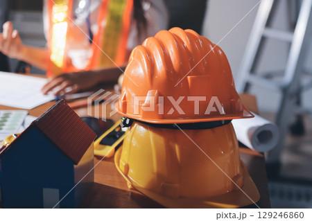 Closeup of team of industrial engineers meeting analyze machinery blueprints consult project on table in manufacturing factory. Working in manufacturing plant or production plant. 129246860