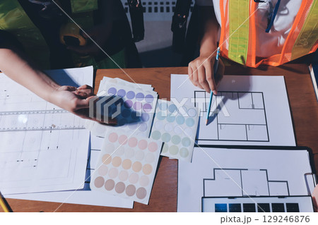 Closeup of team of industrial engineers meeting analyze machinery blueprints consult project on table in manufacturing factory. Working in manufacturing plant or production plant. Closeup of team of industrial engineers meeting analyze machinery blueprints consult project on table in manufacturing factory. Working in manufacturing plant or production plant. 129246876