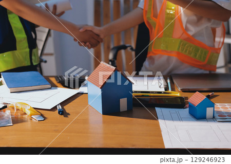 Closeup of team of industrial engineers meeting analyze machinery blueprints consult project on table in manufacturing factory. Working in manufacturing plant or production plant. Closeup of team of industrial engineers meeting analyze machinery blueprints consult project on table in manufacturing factory. Working in manufacturing plant or production plant. 129246923