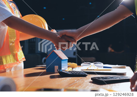 Closeup of team of industrial engineers meeting analyze machinery blueprints consult project on table in manufacturing factory. Working in manufacturing plant or production plant. 129246928