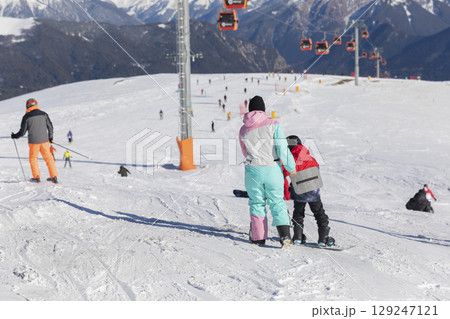 Skiers, snowboarders skiing in a mountain ski 129247121