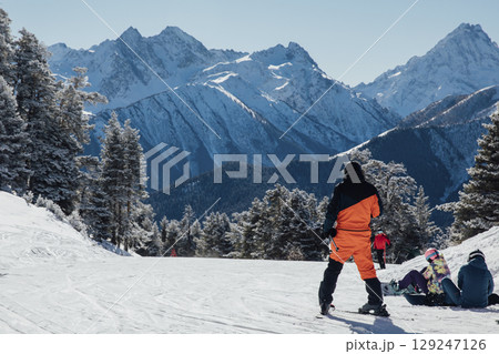 Snowboarders and skiers ski in the resort on the slopes 129247126