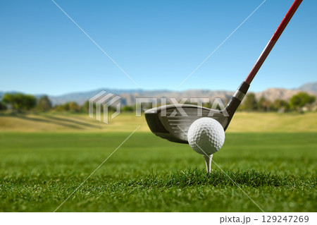 Golf driver and ball on tee with mountain view background Golf driver and ball on tee with mountain view background 129247269