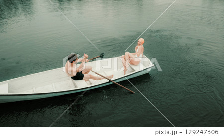 Man and woman in vintage swimsuits splashing water in boat with joyful expression Man and woman in vintage swimsuits splashing water in boat with joyful expression 129247306
