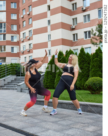 Two women in activewear celebrating with high five after outdoor workout Two women in activewear celebrating with high five after outdoor workout 129247382