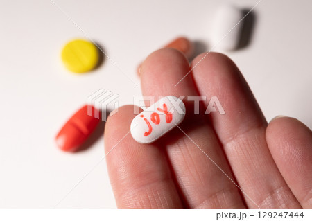 Pills Representing Joy in a Hand Showcase the Struggle With Addiction and Mental Health 129247444