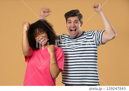 Cheerful african woman man raise fists in victory.Couple celebration, motivation 129247843