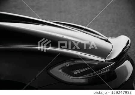 ツヤツヤの黒いスポーツカーのテールランプとスポイラー 129247958