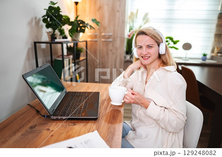 Working from home with joy while sipping a warm beverage 129248082