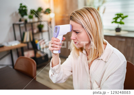 Measuring body temperature at home during a health checkup 129248083