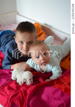 Sibling Bonding on Bed with Toy Sheep 129248106