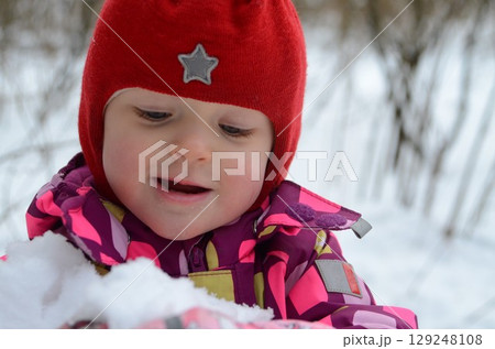 Child Enjoying Snow in Colorful Winter Clothing 129248108
