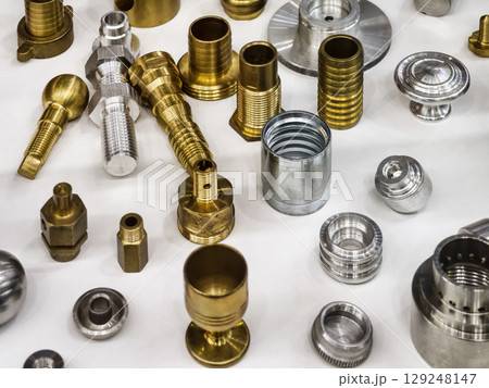 Variety of metal components in different finishes arranged on a work surface for inspection and analysis 129248147