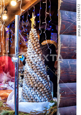 Homemade decorating Christmas tree made of natural snails shells. DIY simple Xmas tree decorated with lights, zero waste holiday Homemade decorating Christmas tree made of natural snails shells. DIY simple Xmas tree decorated with lights, zero waste holiday 129248572