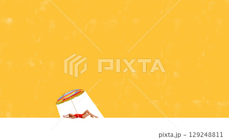 Bold bright poster of woman sunbathing under umbrella on vibrant yellow background with large copy space 129248811