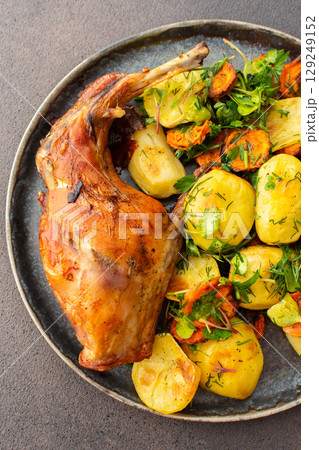 Baked rabbit with potatoes and carrots, a set table with food Baked rabbit with potatoes and carrots, a set table with food 129249152