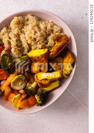 This breakfast bowl features quinoa, baked sweet potato, carrots, zucchini, broccoli, beans, baked chicken with turmeric,perfect for an energizing morning 129249218