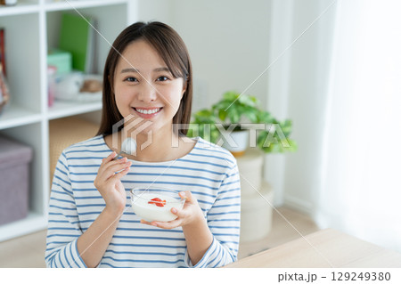 ヨーグルトを食べる若い女性 129249380