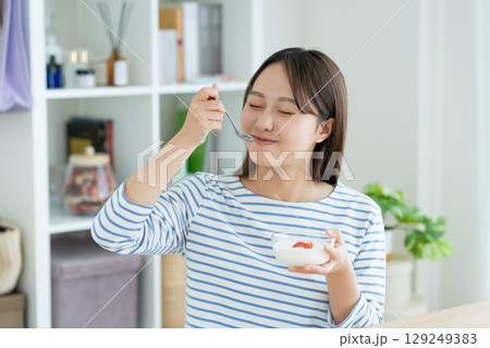 ヨーグルトを食べる若い女性 129249383