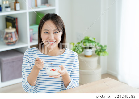 ヨーグルトを食べる若い女性 129249385